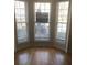 Sunlit living room with gleaming hardwood floors and large windows, offering a bright and airy space at 1843 Grove Way, Hampton, GA 30228