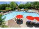 Large community pool surrounded by lounge chairs, umbrellas, and lush greenery at 2313 Saint Davids Nw Sq # 12, Kennesaw, GA 30152