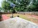 View of the backyard showcasing a patio, basketball hoop, red brick trim, and a wood fence at 3625 Ennfield Ln, Duluth, GA 30096