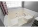 Close-up of a soaking tub with tile surround and fixtures at 3625 Ennfield Ln, Duluth, GA 30096