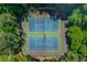 Aerial view of community tennis courts, fully fenced and surrounded by trees, offering a private recreational space at 3625 Ennfield Ln, Duluth, GA 30096