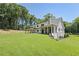 Spacious backyard with a large lawn, mature trees, and a covered porch at 779 Hicks Rd, Canton, GA 30115