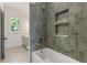 Gray tiled shower and tub in a modern bathroom with a view from the window at 779 Hicks Rd, Canton, GA 30115