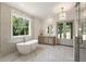 Bright bathroom featuring marble floors, double vanity, soaking tub, and backyard view at 779 Hicks Rd, Canton, GA 30115