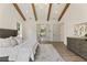 Bright bedroom featuring hardwood floors, exposed ceiling beams, and a decorative area rug at 779 Hicks Rd, Canton, GA 30115