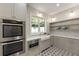 Butler's pantry features stone backsplash, stainless appliances, window, and decorative shelving at 779 Hicks Rd, Canton, GA 30115