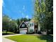 Inviting two-story home featuring manicured lawn, attached garage, and mature shade trees under a partly cloudy sky at 1600 Brisbane Drive, Dacula, GA 30019