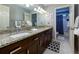 Bathroom featuring double sink vanity with granite countertop, decorative mirrors, and adjacent toilet room at 2882 Clary Hill Ne Dr, Roswell, GA 30075