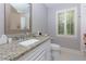 Bathroom featuring a granite countertop, a vanity, a window with shutters, and a toilet at 2882 Clary Hill Ne Dr, Roswell, GA 30075