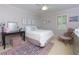 Cozy bedroom featuring a comfortable bed, desk, and window with plantation shutters for natural light at 2882 Clary Hill Ne Dr, Roswell, GA 30075
