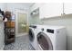 Functional laundry room with modern washer and dryer units and decorative tiled flooring at 2882 Clary Hill Ne Dr, Roswell, GA 30075