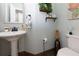 Decorated powder room featuring a pedestal sink, wall shelves with decorations, and tile flooring at 2882 Clary Hill Ne Dr, Roswell, GA 30075