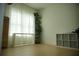 Bright bedroom featuring neutral walls, wood floors, and a window with patterned curtains and shelving at 423 Ward Ln, Woodstock, GA 30188