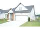 Attractive home featuring a side lawn, a two-car garage, a concrete driveway, and craftsman style columns at 423 Ward Ln, Woodstock, GA 30188