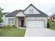 Charming single Gathering home featuring brick accents, a two-car garage and a well manicured lawn at 423 Ward Ln, Woodstock, GA 30188