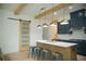 Modern kitchen with a large island, stylish light fixtures, and a sliding barn door at 423 Ward Ln, Woodstock, GA 30188