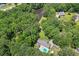 Expansive aerial view of a private estate with a lush landscape, sparkling pool, and serene lake at 4825 Rollins Dr, Powder Springs, GA 30127
