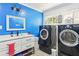 Updated laundry room featuring front load washer and dryer and custom cabinets at 4825 Rollins Dr, Powder Springs, GA 30127