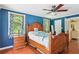 Comfortable bedroom with a ceiling fan, hardwood floors, and natural light from two windows at 4825 Rollins Dr, Powder Springs, GA 30127