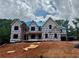 New construction home featuring blue roof, covered porch and views of a wooded lot at 2808 Carson Garrett Ct, Buford, GA 30519
