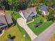 Aerial view of a beautifully landscaped home with lush green lawn, long driveway, and mature trees at 3445 Henderson Dr, Cumming, GA 30041