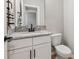 Modern powder room featuring granite countertops, white cabinets, and dark hardware at 3445 Henderson Dr, Cumming, GA 30041