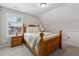 Cozy bedroom features a wood bed frame, plush carpeting, and natural light from window at 3445 Henderson Dr, Cumming, GA 30041