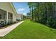Large landscaped backyard, a sidewalk leading toward trees and a beautiful, white home with screened porch at 3445 Henderson Dr, Cumming, GA 30041
