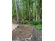 Tranquil backyard setting with mature trees, stone-lined flower beds, and a peaceful ambiance at 72 Victorian Cir, Dallas, GA 30157