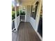 Welcoming front porch with gray siding, black shutters, and a colorful wreath adorning the front door and wood floors at 72 Victorian Cir, Dallas, GA 30157