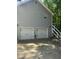 Attached two-car garage with white doors and dark handles, complemented by exterior lighting at 72 Victorian Cir, Dallas, GA 30157