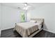 Clean bedroom features neutral walls, modern floors, a ceiling fan and a sunlit window at 870 Underhill Ct, Sugar Hill, GA 30518