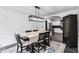 Elegant dining room with stylish lighting and hardwood floors, flowing into a modern kitchen at 870 Underhill Ct, Sugar Hill, GA 30518