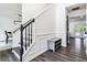 Bright entryway showcasing hardwood floors, staircase with black handrail, and a decorative bench at 870 Underhill Ct, Sugar Hill, GA 30518