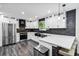 Modern kitchen featuring white cabinets, stainless steel appliances, and a breakfast bar at 870 Underhill Ct, Sugar Hill, GA 30518