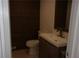 Stylish half bathroom with wood panel accent wall, modern vanity, and fixtures at 2814 Shellbark Rd, Decatur, GA 30035