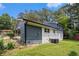 View of the home's backyard, featuring fresh grass, mature trees, and blue and white exterior at 479 Charter Oak Sw Dr, Atlanta, GA 30331