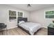 Cozy bedroom features wood-look floors, a large window, a comfortable bed, and a modern chair at 479 Charter Oak Sw Dr, Atlanta, GA 30331