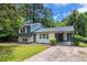 Two-story home featuring a partial white brick facade, complemented by blue siding and a covered carport at 479 Charter Oak Sw Dr, Atlanta, GA 30331