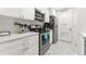 Kitchen featuring white cabinets, stainless steel appliances, and tile flooring at 1424 Tuxworth Cir, Decatur, GA 30033
