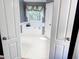 Bright bathroom with a soaking tub, window with decor, and white tiled floors, perfect for relaxation at 1890 Turtle Creek Way, Lawrenceville, GA 30043