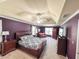 Luxurious main bedroom with a tray ceiling, plush carpet, sitting area, and ample natural light at 1890 Turtle Creek Way, Lawrenceville, GA 30043