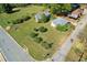 Aerial view displays overgrown lot featuring two small buildings and surrounding streets in neighborhood at 21 Elm St, Hampton, GA 30228