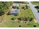 Aerial view features an overgrown lot with two buildings surrounded by green space and foliage at 21 Elm St, Hampton, GA 30228