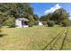 Real estate image of a home with a lawn, bushes and a backdrop of tall green trees at 21 Elm St, Hampton, GA 30228