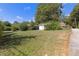 Property featuring a spacious front yard and charming trees beneath a bright blue sky at 21 Elm St, Hampton, GA 30228