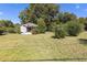 Image showcasing a lawn with trees and bushes and house under a sunny blue sky at 21 Elm St, Hampton, GA 30228