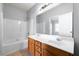 Bathroom featuring a double vanity, tub, and shower combination, illuminated by modern lighting at 7177 Fringe Flower Dr, Austell, GA 30168