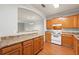 Well-lit kitchen with wooden cabinets, white appliances, and an open layout to the living space at 7177 Fringe Flower Dr, Austell, GA 30168