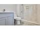 Bathroom featuring blue vanity, white toilet and new shower with marble tile at 1382 Bennett Rd, Grayson, GA 30017